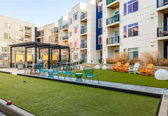 A patio area with a table and chairs is surrounded by apartment buildings. at Indigo 301, King of Prussia