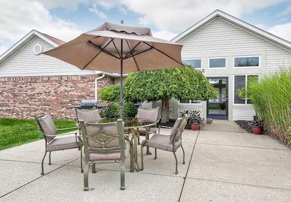 a patio with a table and chairs under an umbrella