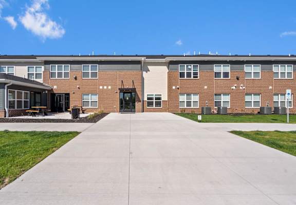 a large brick building with a concrete walkway in front of it