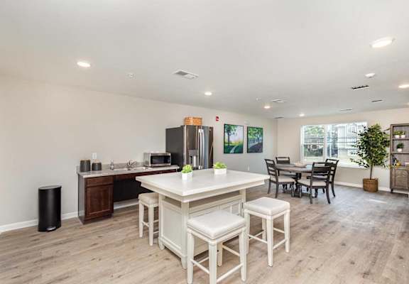A kitchen with a white table and chairs.