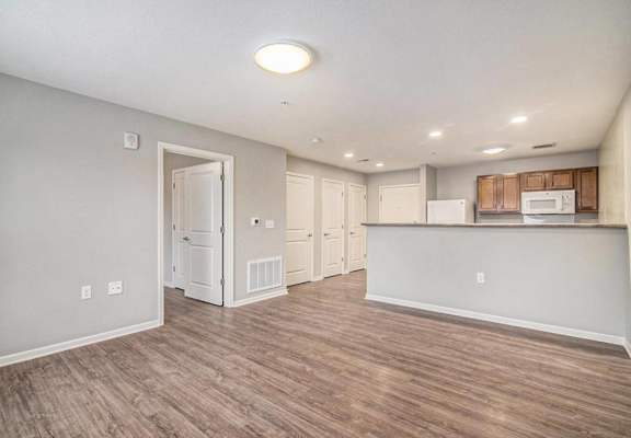the living room and kitchen of a new home with wood flooring
