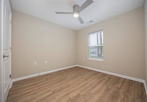 A room with a ceiling fan and a window.