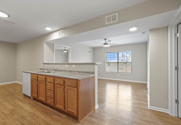 a kitchen and living room with a sink and a mirror