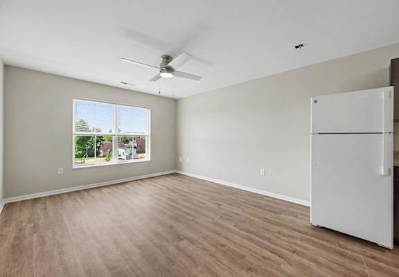 Empty room with a window and a ceiling fan.