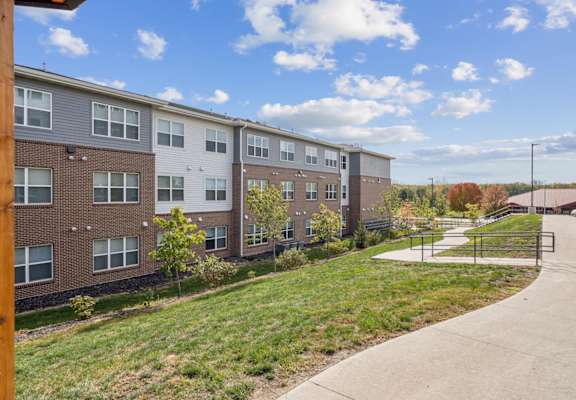 Apartment complex with a walkway in front.