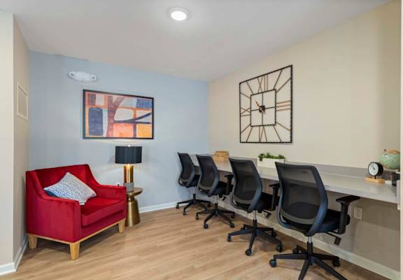 a conference room with a desk and chair and a red couch