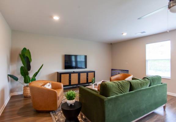 a living room with a green couch and a tv