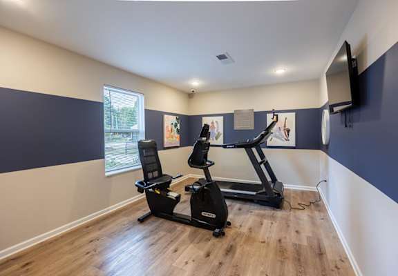 A room with a treadmill and exercise bike.