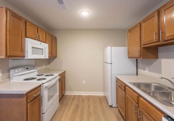 A kitchen with wooden cabinets and white appliances.