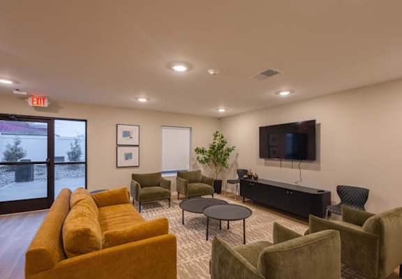 A living room with a yellow couch and a flat screen TV.