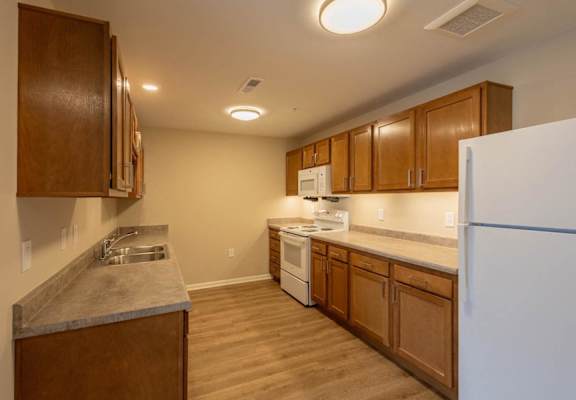 A kitchen with wooden cabinets and a white refrigerator.