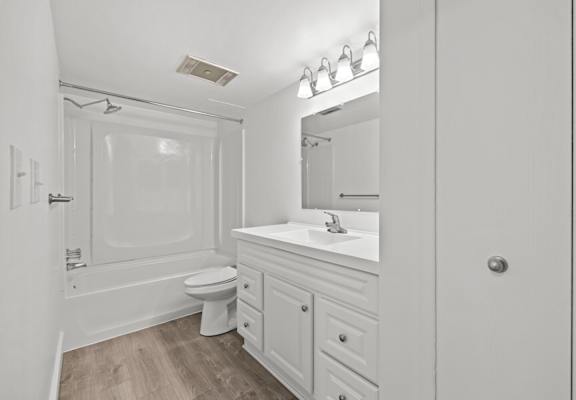 A white bathroom with a toilet, sink, and mirror.
