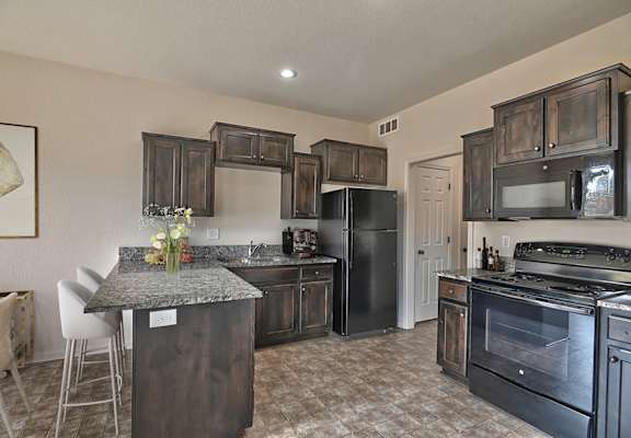 A kitchen with black appliances and wooden cabinets.