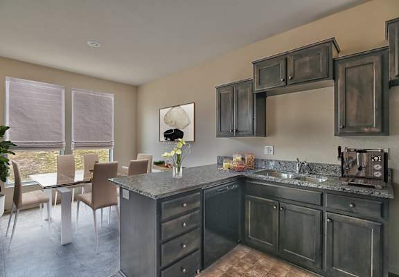 A kitchen with a table and chairs.