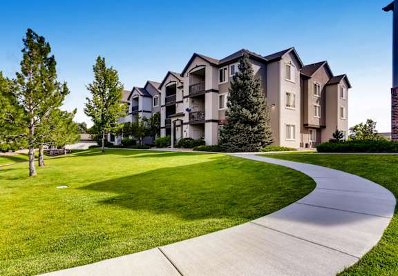 A residential building with a green lawn in front.