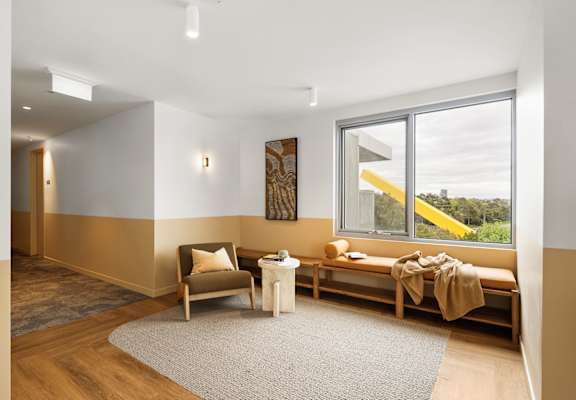 A room with a chair, a bench, and a table.