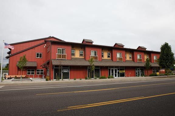 A modern building with a parking lot in front of it.