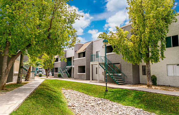 A residential area with a cobblestone path and green trees.