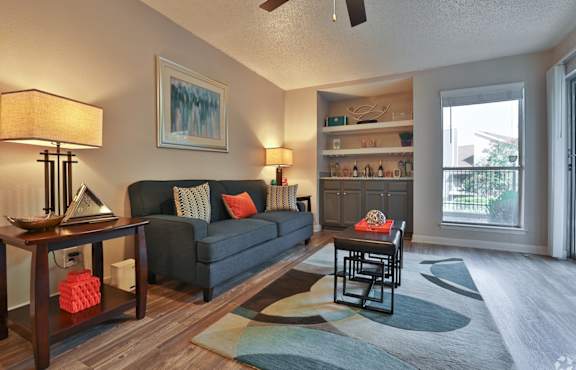 A living room with a couch, a table, and a painting on the wall.