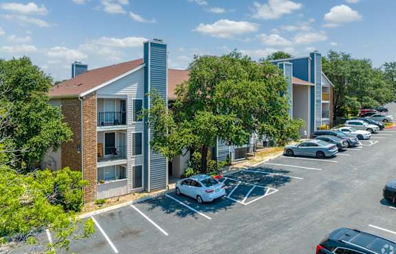 A parking lot with cars and a building in the background.