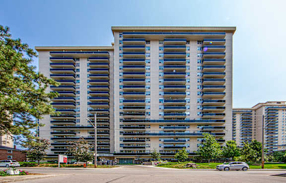 A large, modern building with a parking lot in front.