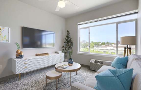 A living room with a couch, a television, a table, and a plant.