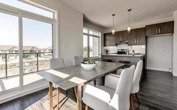 A modern kitchen with a dining table and chairs.