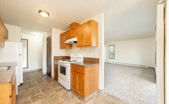 Kitchen with wooden cabinets and a white stove top oven at Concord Crossing, Milwaukie