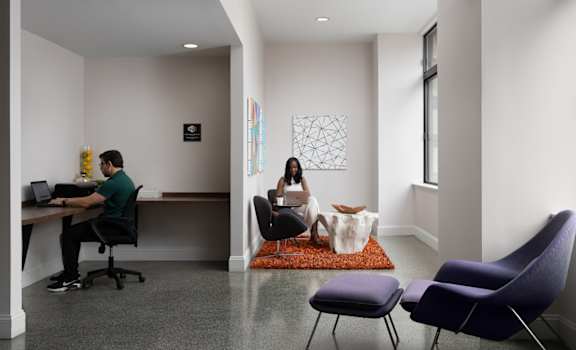 a man and a woman sitting at a desk in an office