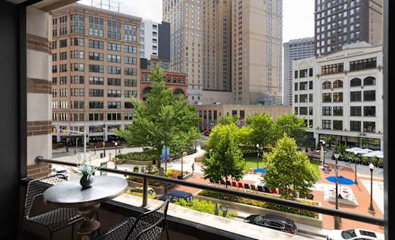 a view of the city from a window with trees and tall buildings