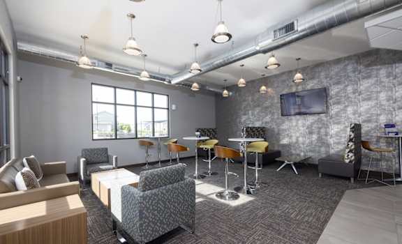 A modern office space with grey walls and a variety of seating options.