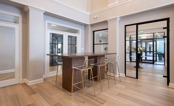 a kitchen with a bar and chairs in a room with doors  at Vivant Woodholme, Maryland, 21208