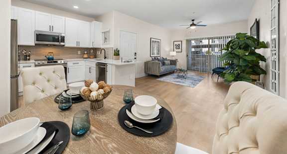 A modern kitchen with a dining table set for two.