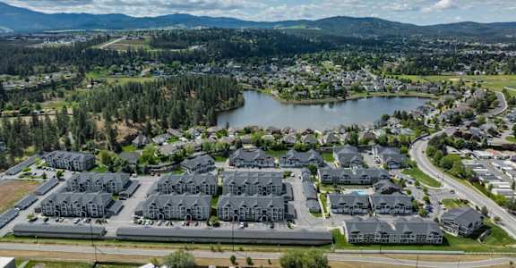a city from the sky with houses and a lake