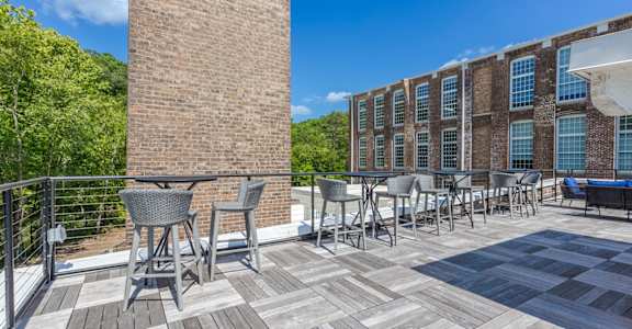 A patio with a table and chairs is surrounded by a brick building.