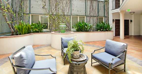 a patio with chairs and a table in front of a building