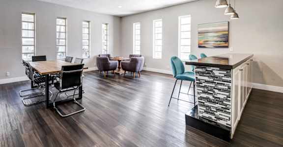 A modern dining room with a wooden floor and a large island.