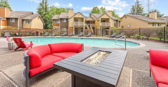 A poolside seating area with a fire pit in the middle at MonteVista Apartments, Beaverton, 97007