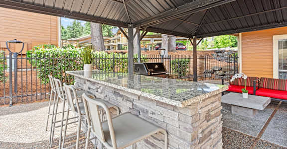 A patio with a bar and chairs under a roof at MonteVista Apartments, Beaverton