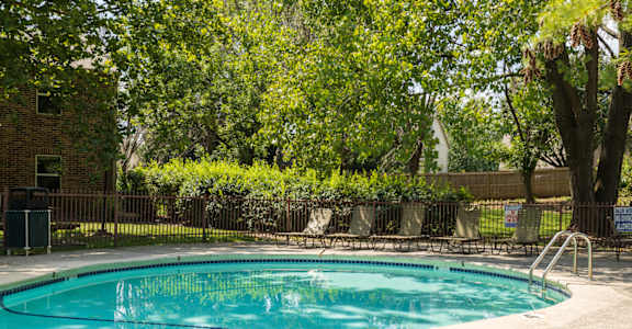 A sparkling pool with lounge chairs and umbrellas for a relaxing afternoon.