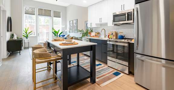 a kitchen with stainless steel appliances and a table with chairs