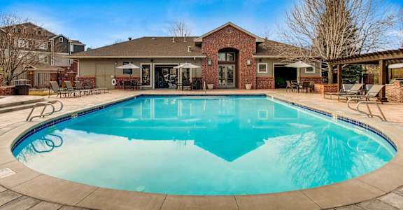 A swimming pool in front of a house.