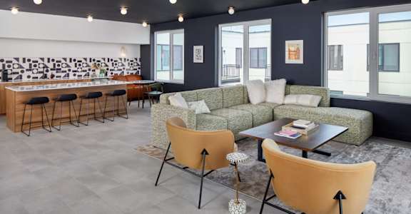 A living room with a grey floor and a white wall with a black and white mural at The Weaver, Philadelphia