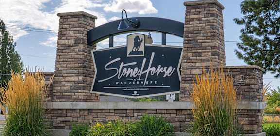 A sign that says Stonehorse Wanderlust in front of a grassy area.