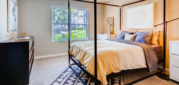 a bedroom with a canopy bed and a window