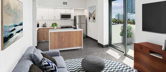 A modern living room with a grey sofa and a grey pouf.
