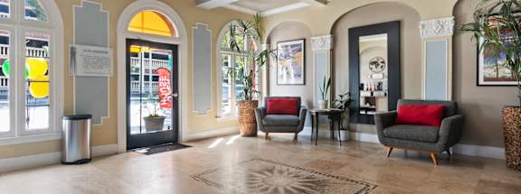 A spacious lobby with a chandelier, sofas, and a large rug.