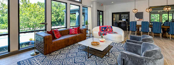 A large, well-lit living room with a couch, chairs, and a coffee table.