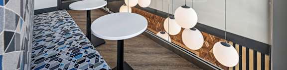 A modern interior with a long table and hanging lights.