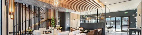 A modern living room with a white sofa and a wooden ceiling.